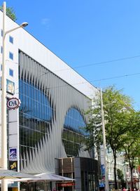 Low angle view of modern building against blue sky