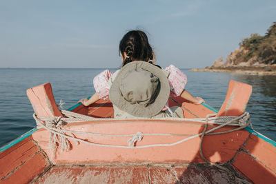 Little girl in the boat watching sea
