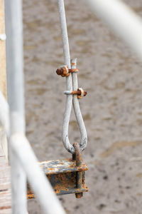 Close-up of rope tied on metal fence