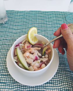 High angle view of woman holding fruit salad in bowl