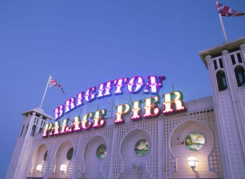 Low angle view of illuminated building against clear blue sky