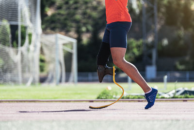 Low section of athlete with prosthetic leg on running track