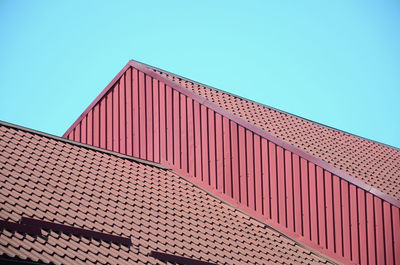 Low angle view of roof and building against clear blue sky