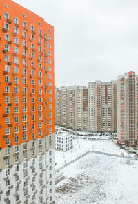 Buildings in city against clear sky during winter