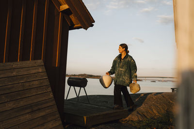 Young woman carrying handmade vases at coast