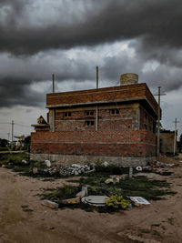 Abandoned building against cloudy sky