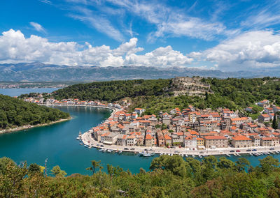 High angle view of river by townscape against sky