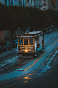 Cars on illuminated street in city at night