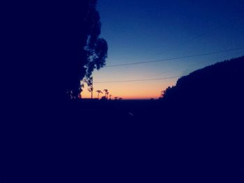 Silhouette landscape against clear sky at sunset
