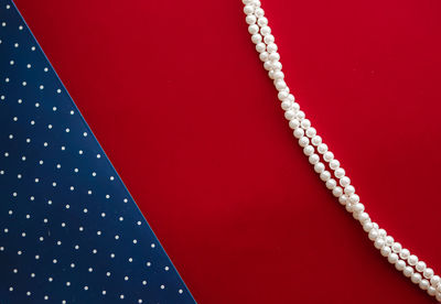 Close-up of pearl jewelry on red background