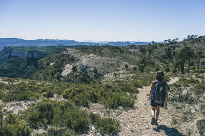 Woman hiking on a mountain path in catalonia on a cloudy summer day