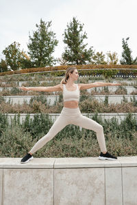 Full length of young woman standing against wall