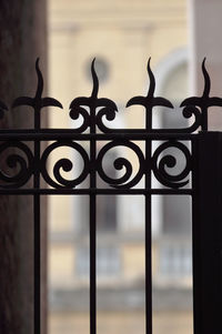 Close-up of metal gate against window