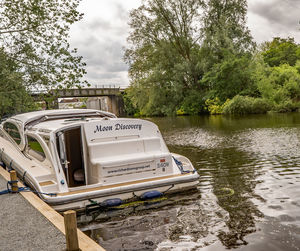 Boat moored on lake by trees