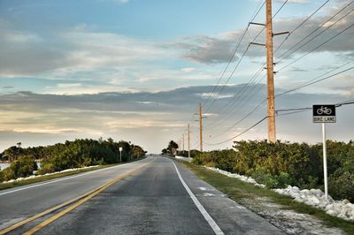 Empty road with trees in background