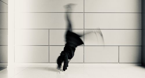 Low section of man walking on floor against wall