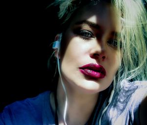 Close-up portrait of a beautiful young woman over black background