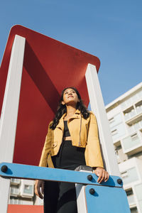 Young woman standing on slide at playground