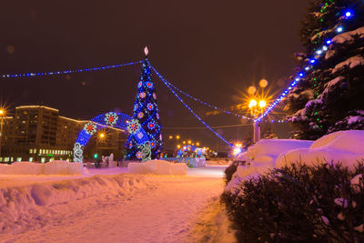 Illuminated christmas tree against sky at night