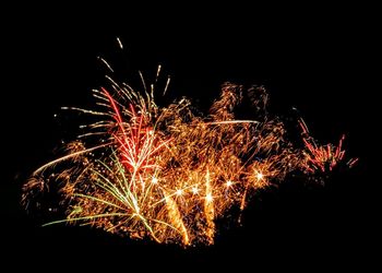 Low angle view of firework display at night