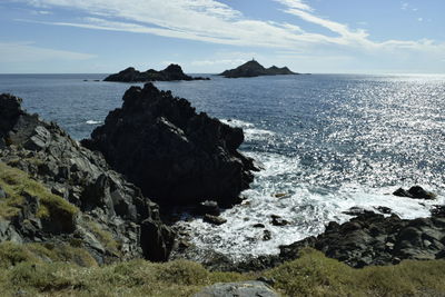 Rock formation on beach against sky