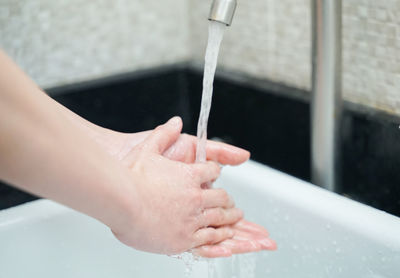 Close-up of hand reaching towards water