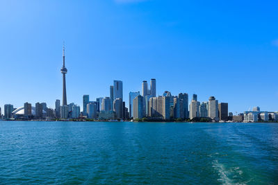 Modern buildings in city against blue sky