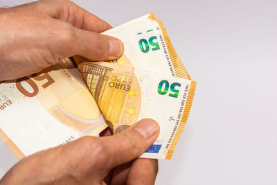 Midsection of woman holding paper against white background