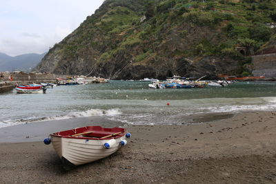 Boats moored on shore against sky