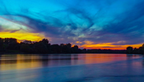 Scenic view of lake against sky during sunset