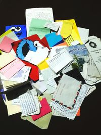 Close-up of multi colored paper papers against black background