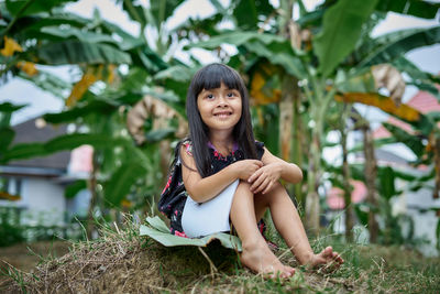 Portrait of smiling girl sitting on land