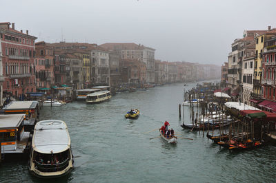 Boats moored in city against clear sky