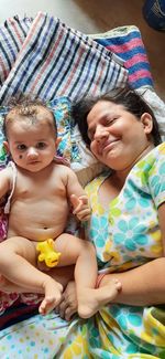 Portrait of a smiling baby girl on bed