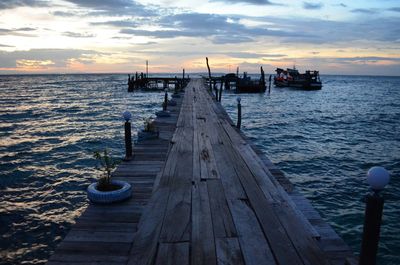 Pier over sea against sky during sunset