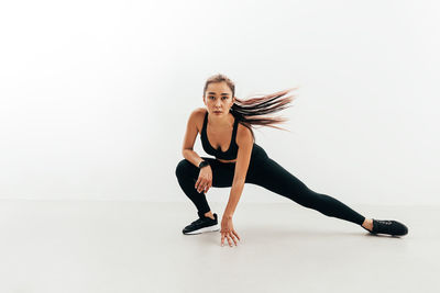 Full length of woman dancing against white background