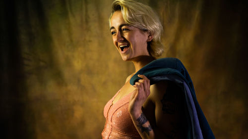 Young woman standing against wall