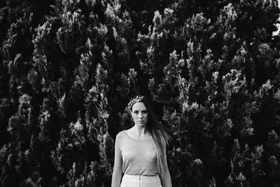 Portrait of woman standing against trees