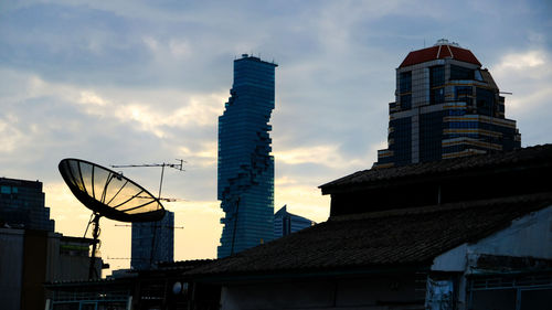 Low angle view of buildings against cloudy sky