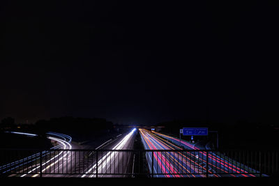 Illuminated light trails on highway at night