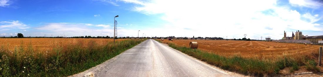 Dirt road passing through field