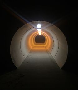 Illuminated tunnel at night