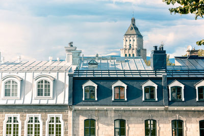 Buildings in city against cloudy sky