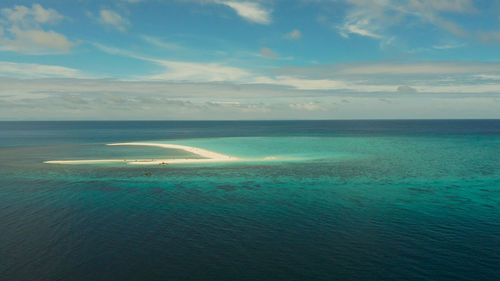 Tropical white island and sandy beach with tourists surrounded by coral reef. camiguin, philippines.