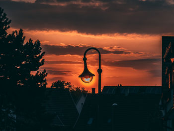 Silhouette tree and buildings against sky during sunset