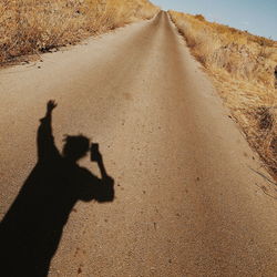 Shadow of person on road