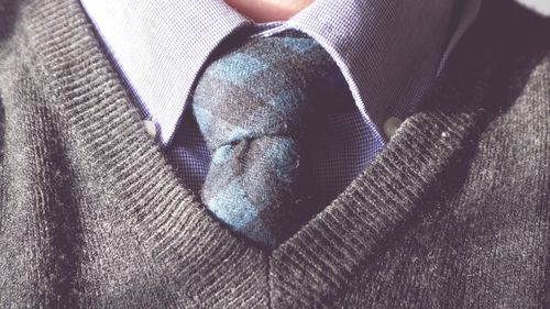 Midsection of man wearing necktie and sweater