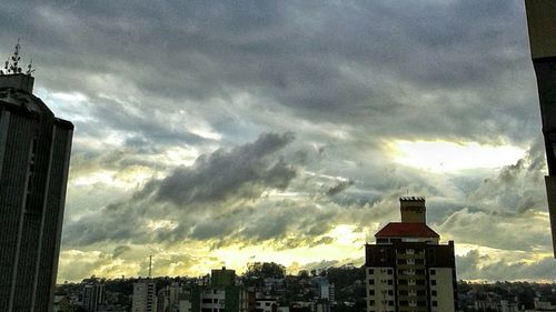 Low angle view of buildings against cloudy sky