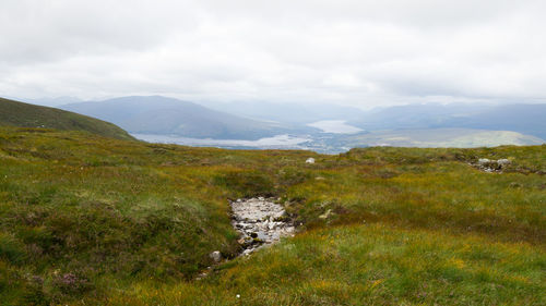 Scenic view of mountains against cloudy sky