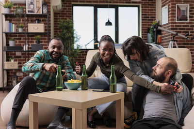 Friends using digital tablet while sitting on table